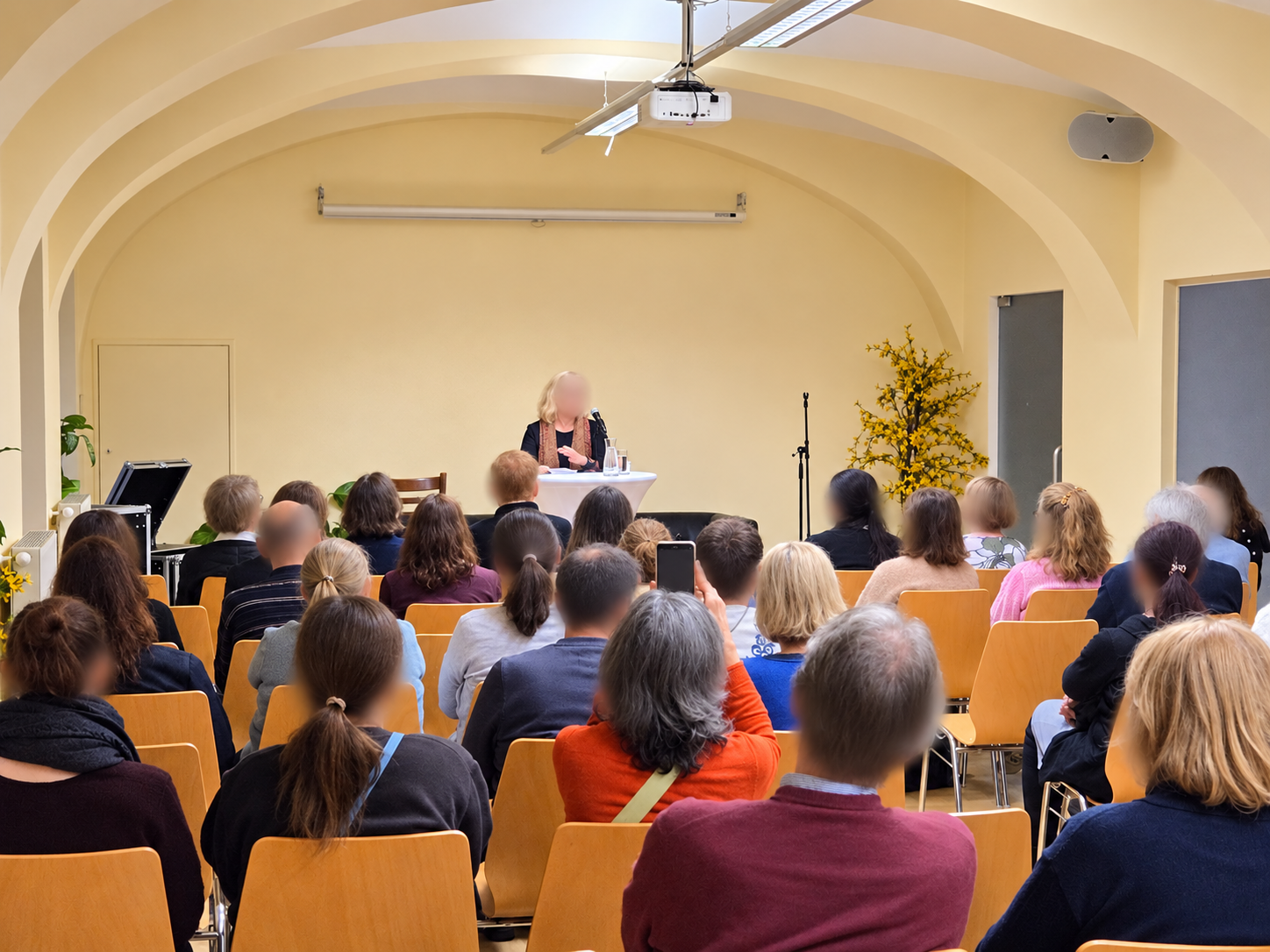 Vortrag mit Mikrofon vor Gästen im Weinberger Saal